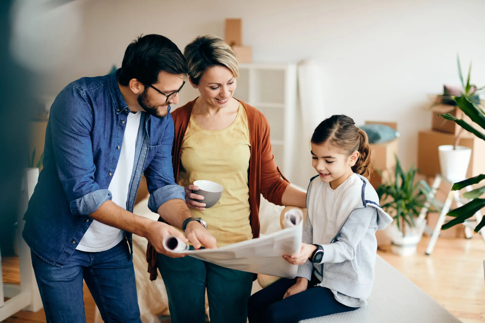 Happy family examining blueprints while relocating into a new house.