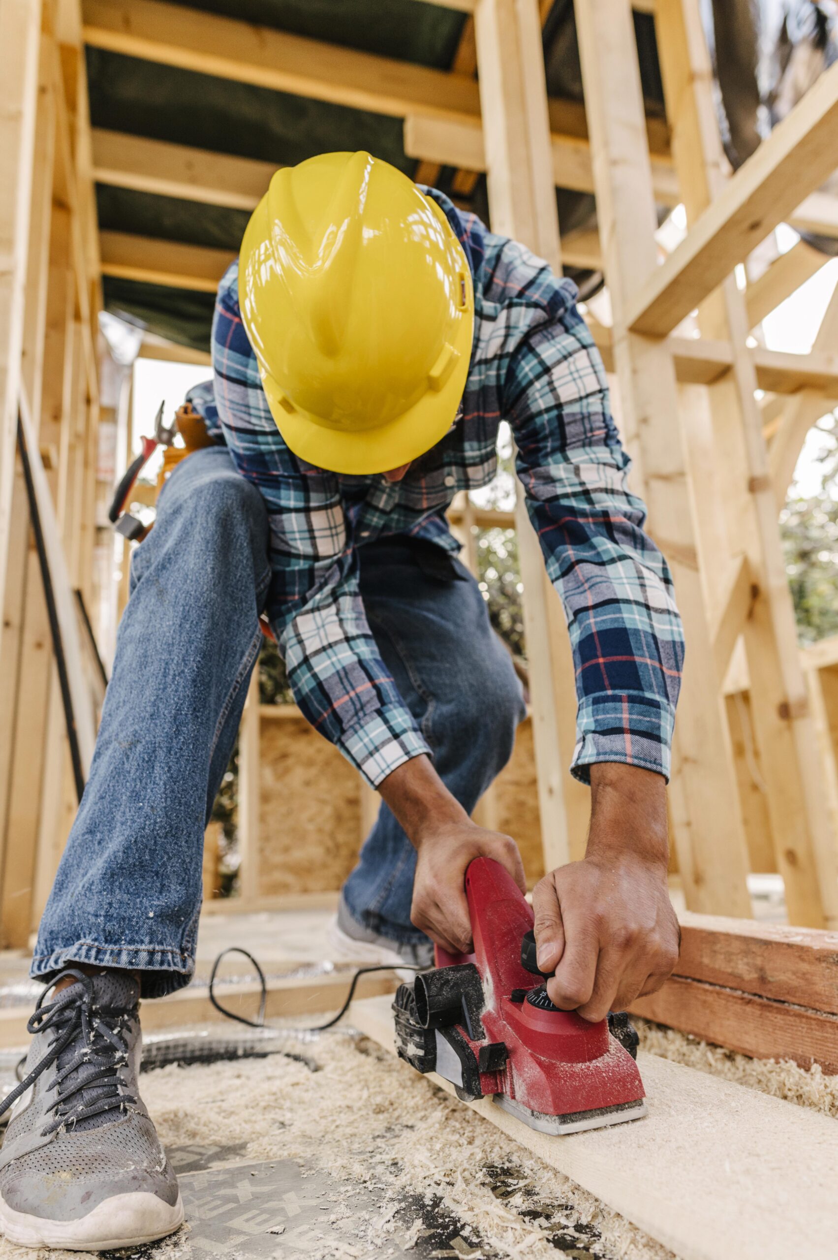 trabajador-de-la-construccion-con-casco-lijando-pieza-de-madera